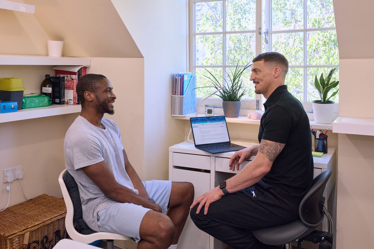 Owain Evans discussing a treatment plan with a patient at MotionFix